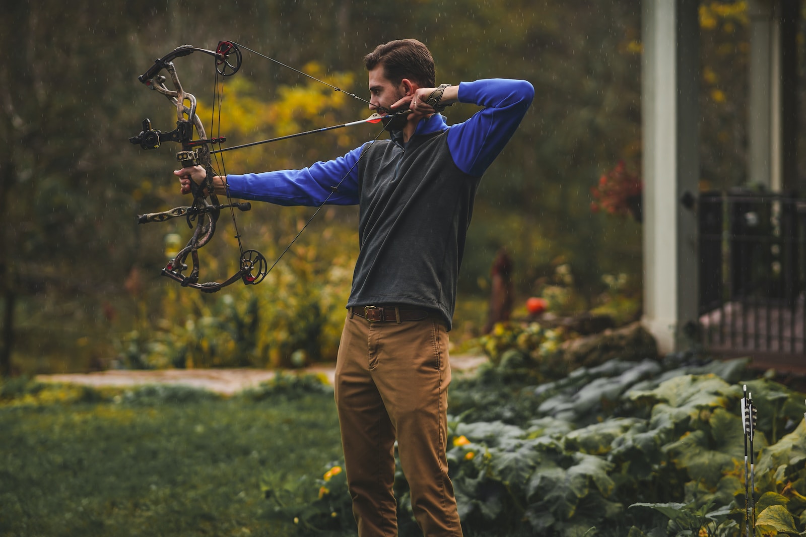 a man is holding a bow and aiming it
